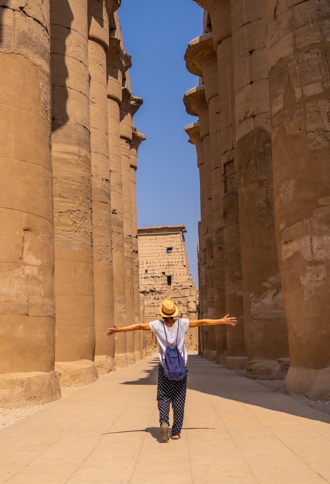 Woman tourist wearing a hat visiting the Egyptian Temple of Luxor. Egypt